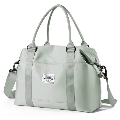 Light gray waterproof duffel bag with dual top handles, detachable shoulder strap, and front logo patch.