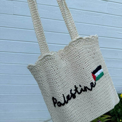 Beige handmade crochet tote bag with "Palestine" script and flag embroidery, long handles.