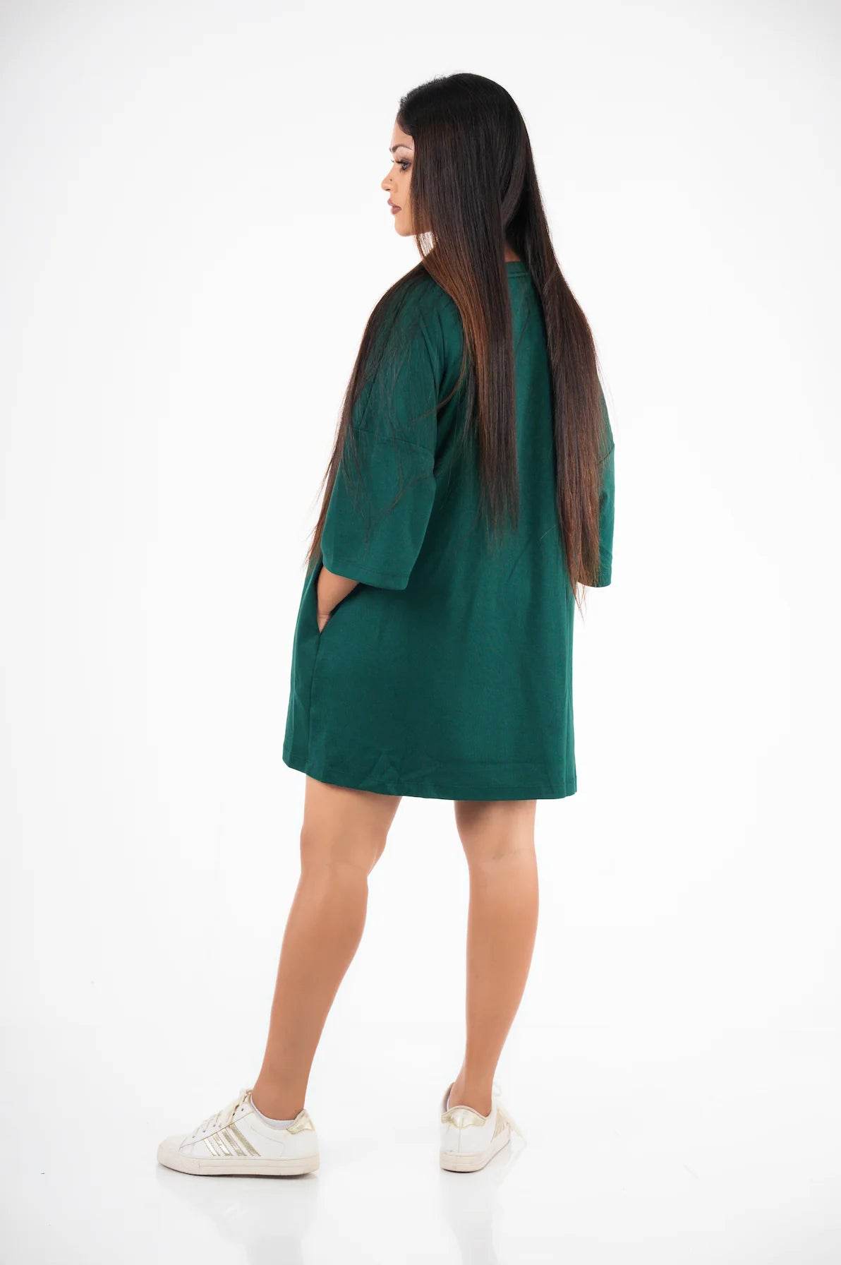 Relaxed fit dark green oversized t-shirt worn with white sneakers, back view.